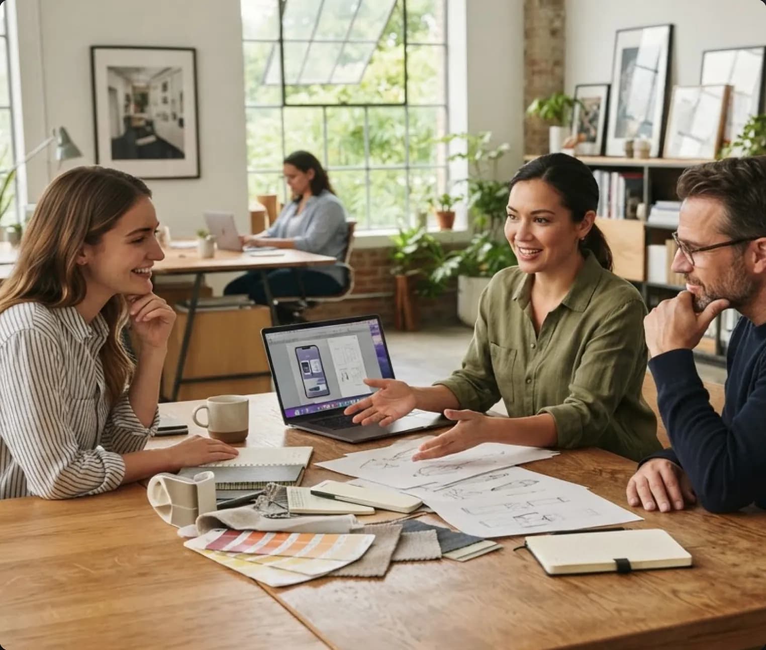 Three colleagues discussing an AI project around a laptop at a wooden table covered in sketches