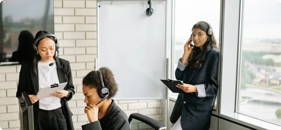 A support team wearing headsets working at their desks
