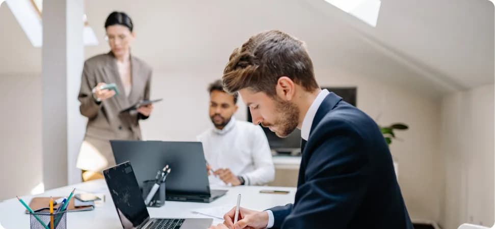 Colleagues working together at a laptop in a bright office